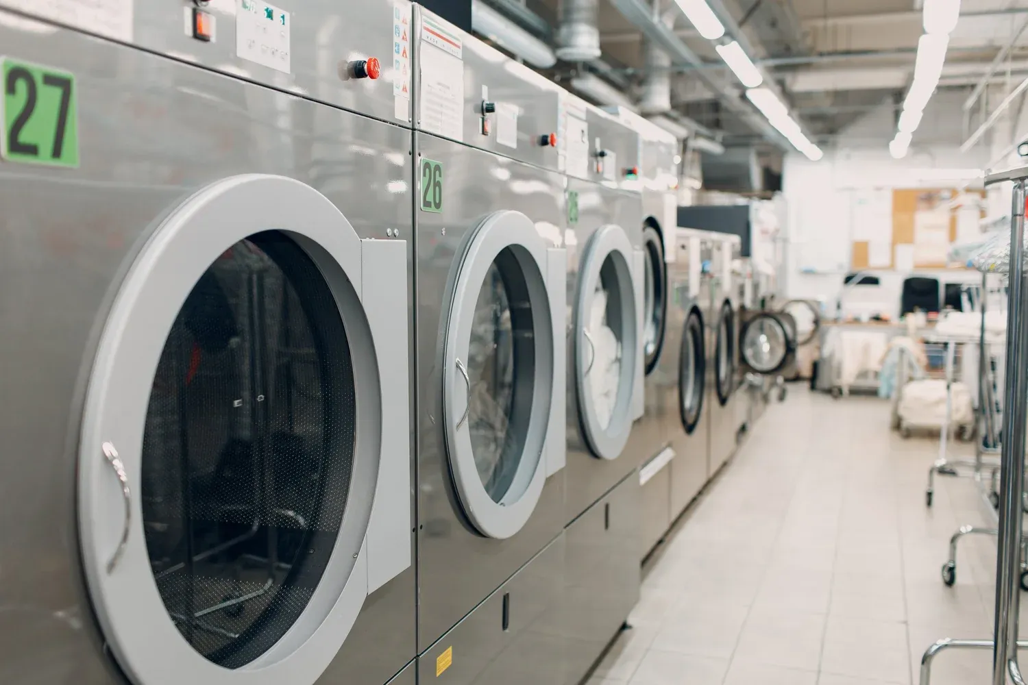 Row of commercial washing machines in a laundry facility