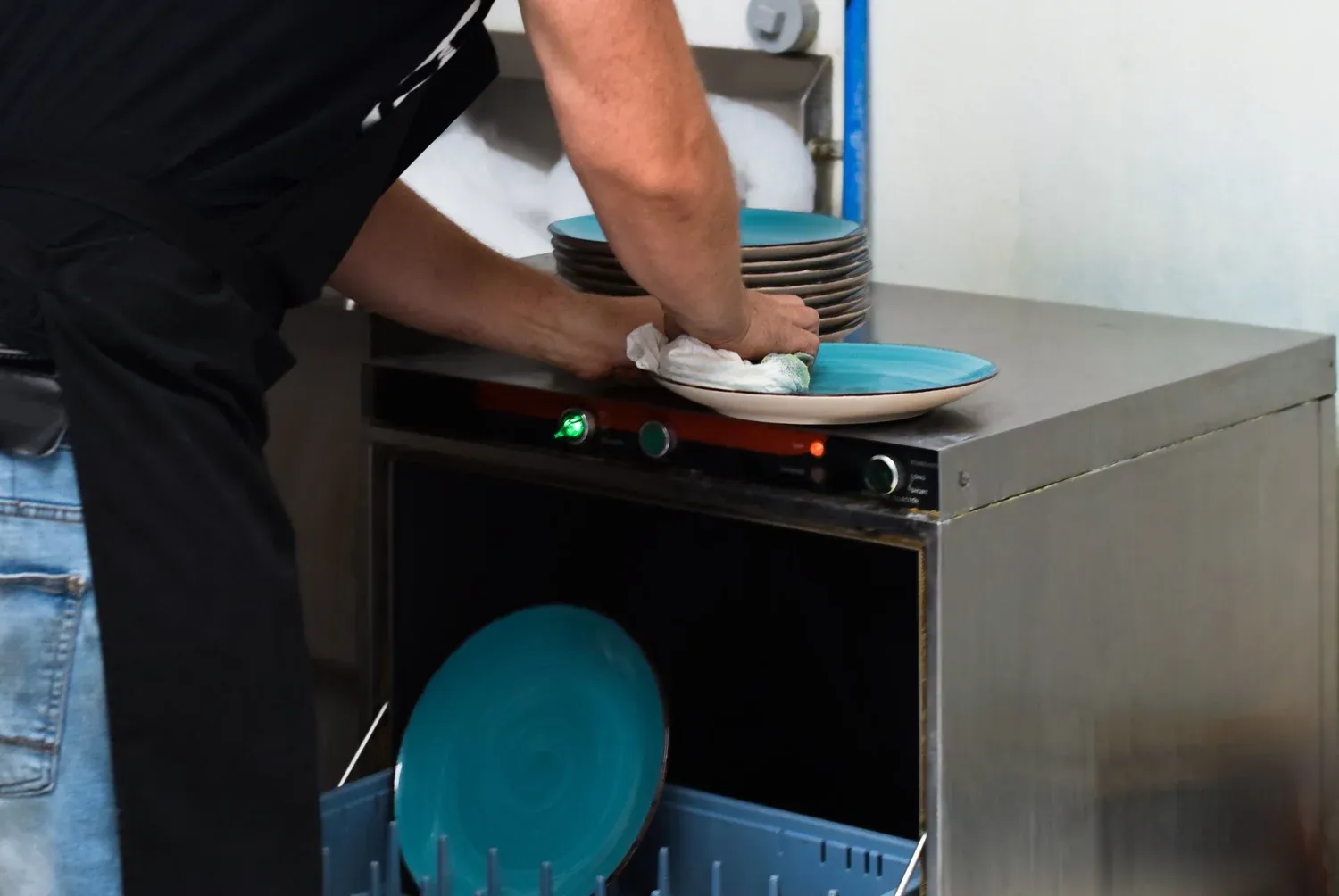 Operator loading plates into a commercial dish machine